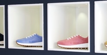 Four shoes with BASF logo  in four colors on a shelf.