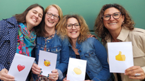 Four women standing close together and laughing  Four women standing close together and laughing