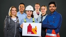 6 Azubis in Arbeitskleidung halten das Key Visual der BASF Münster 6 Azubis in Arbeitskleidung halten das Key Visual der BASF Münster