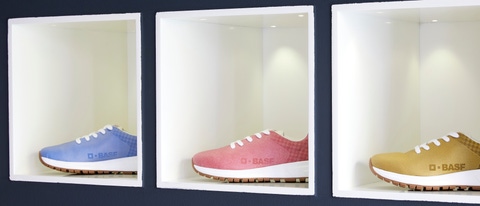 Four shoes with BASF logo  in four colors on a shelf.