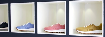 Four shoes with BASF logo  in four colors on a shelf.