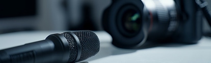 Studio microphone and blurry professional camera on a table  
