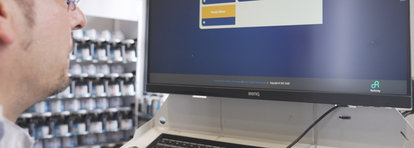 Employee of a body shop looking at a screen displaying the new digital platform Refinity.
