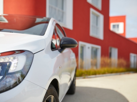 White car in front of a red building White car in front of a red building