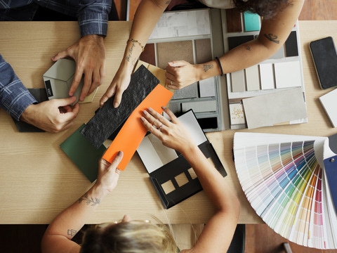 People at a table looking at different colours People at a table looking at different colours