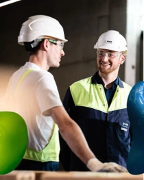 Two workers smiling at each other. 