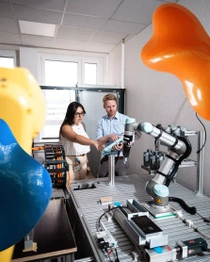 Two people working with robots.